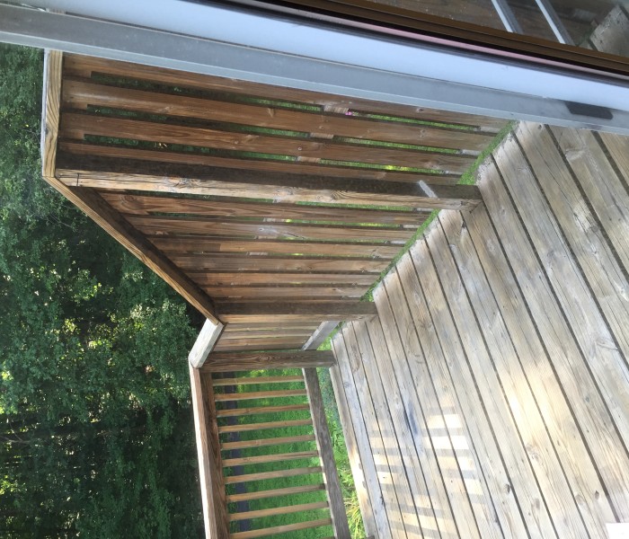 A wooden deck with a railing and a door.