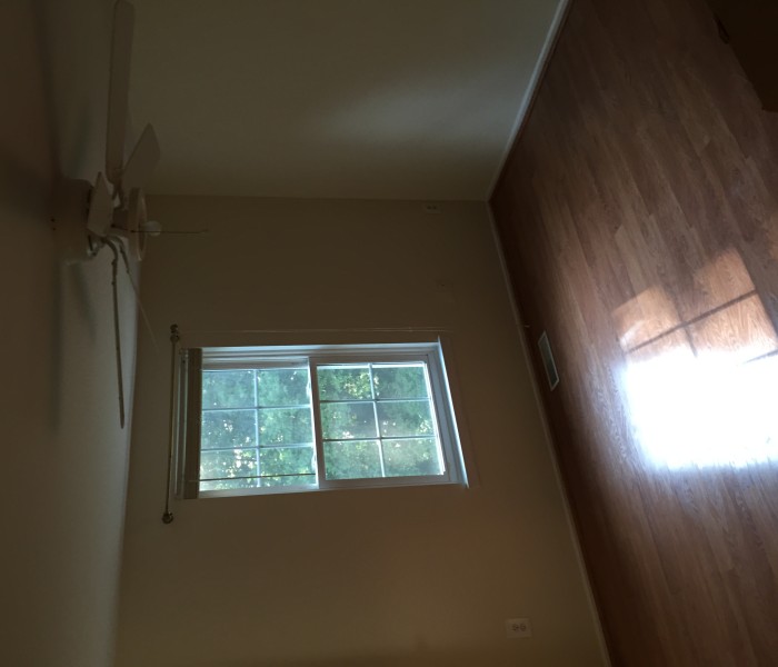 A room with hardwood floors and a ceiling fan.