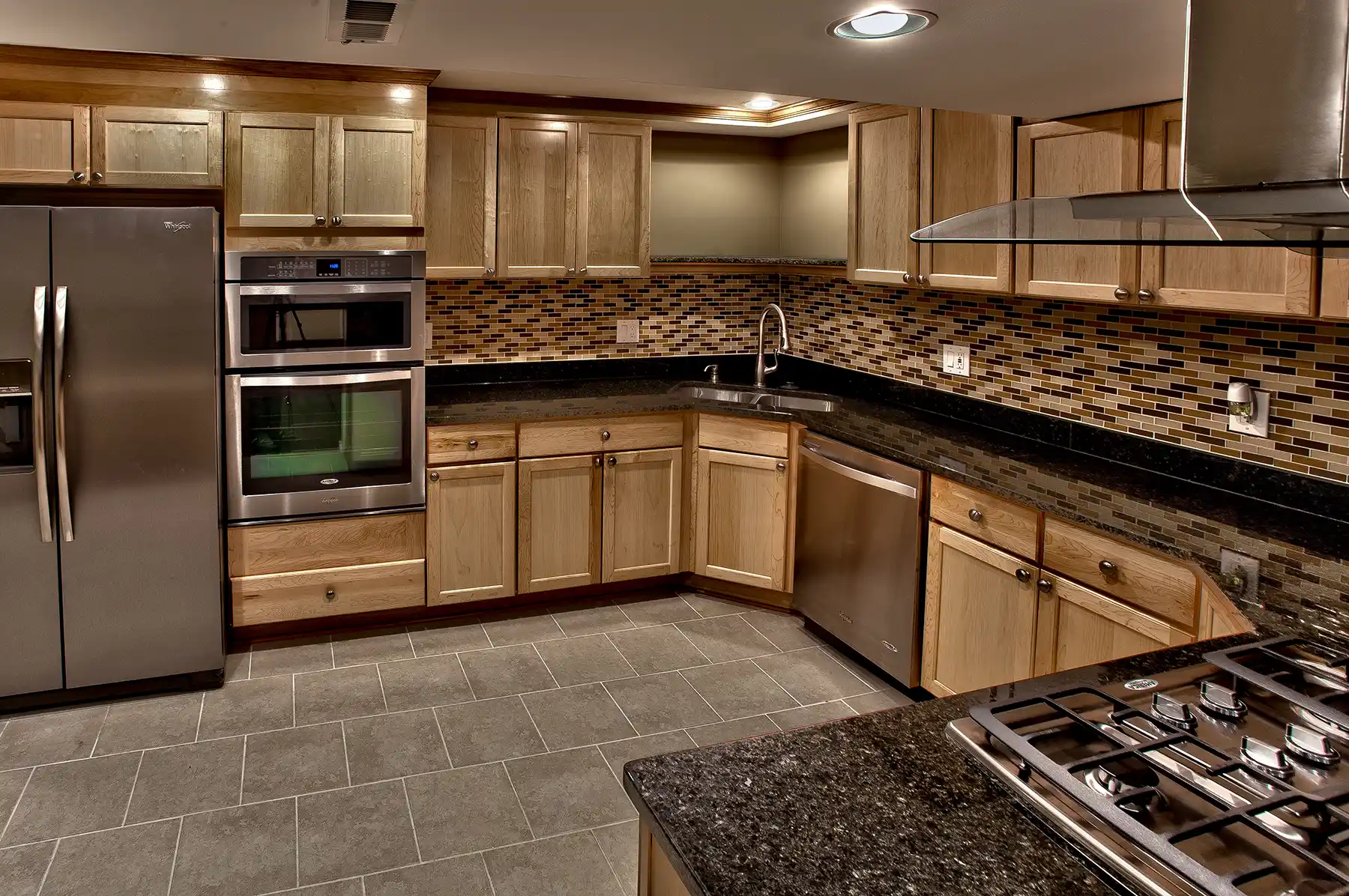 A kitchen with stainless steel appliances and granite counter tops.