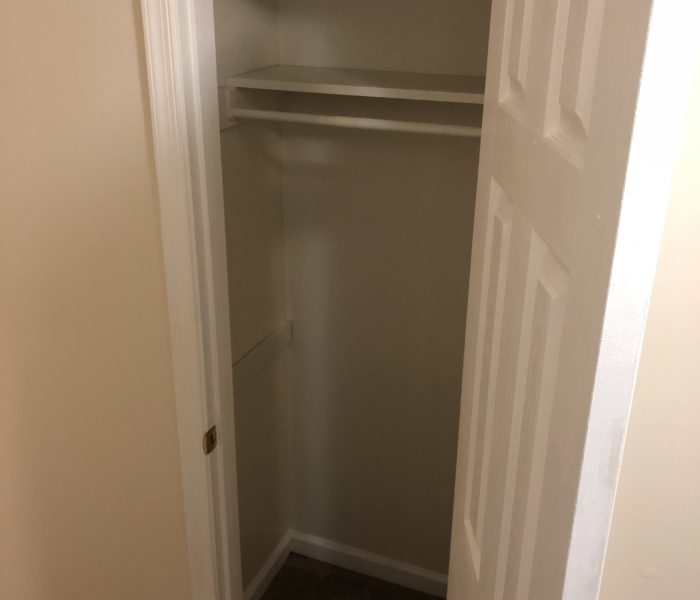 A Wooden Door With Two Rods in a Closet