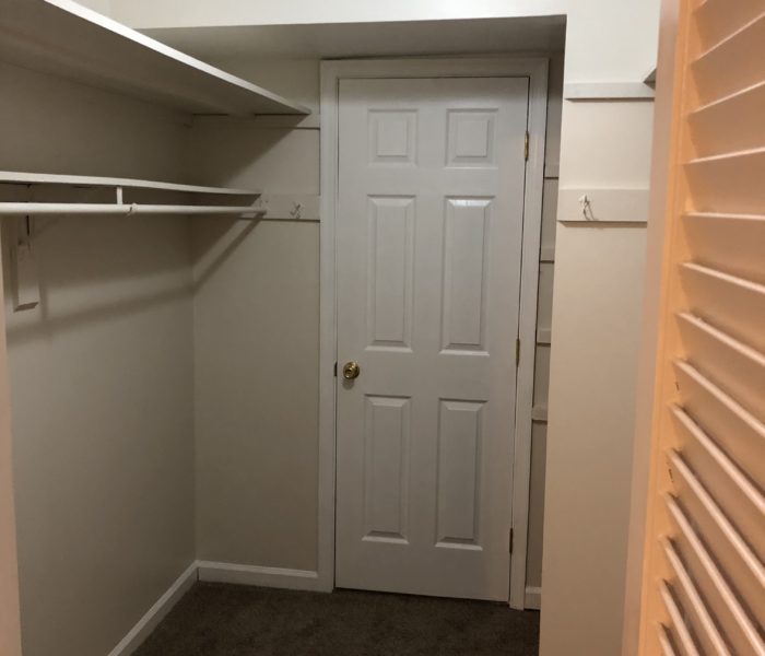 A Wooden Shutter With Shelves and a Rod in a Closet