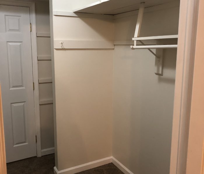 An Empty Closet Space With White Color Hanger