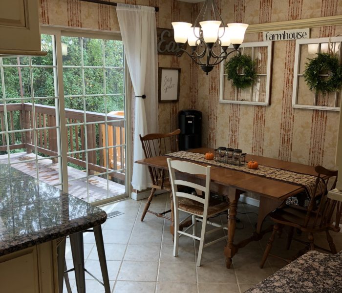 A kitchen with a dining table and chairs.