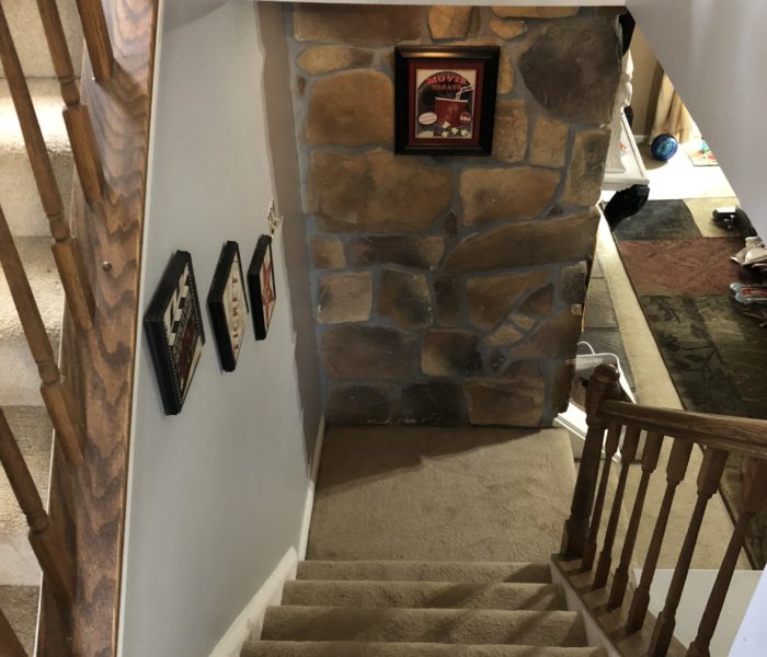 A staircase leading to a room with a picture on the wall.