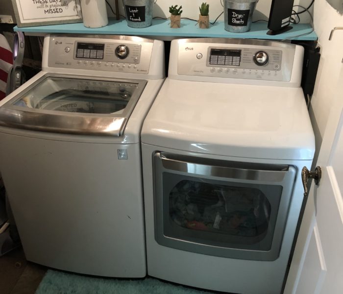 A laundry room with two washers and a dryer.