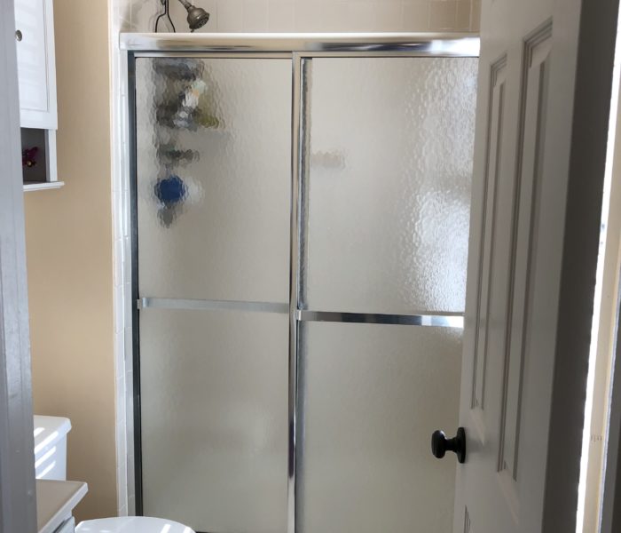 A bathroom with a glass shower door.