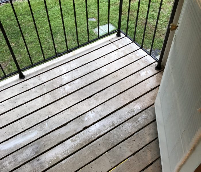 A Wooden Plank Floor With a Black Railing